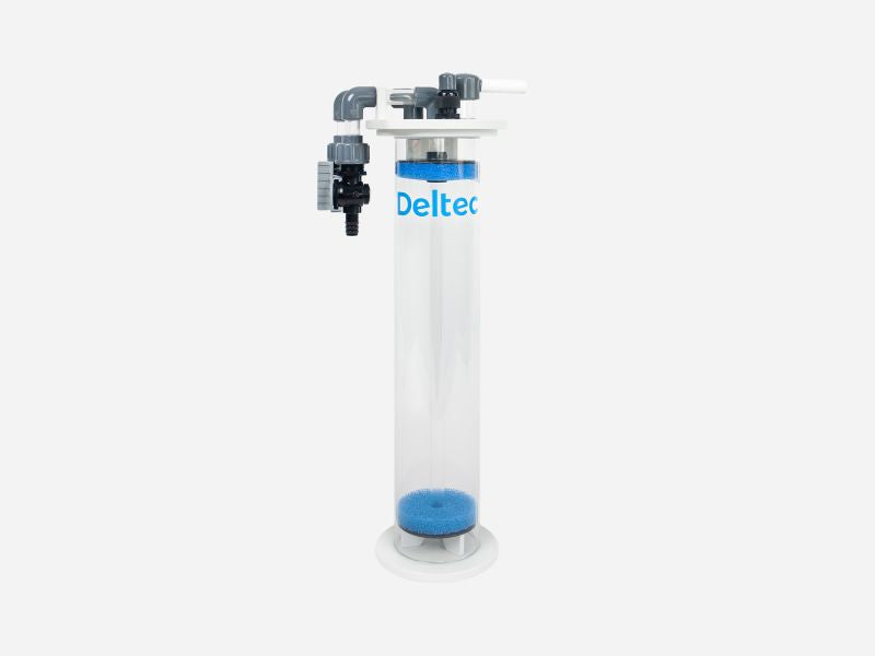 A Deltec cylindrical water filter cartridge with a clear plastic tube, blue filter media at the bottom, and gray plastic fittings on top, shown against a light gray background.